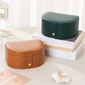Multi-layer D-shaped leather jewelry box in emerald green and brown with metal clasp