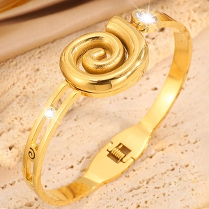 Luxury gold stainless steel bangle with spiral center piece and sparkling rhinestones