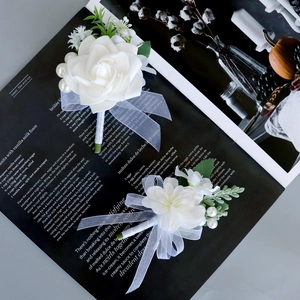Elegant white silk rose boutonniere set with pearls and green leaves for weddings