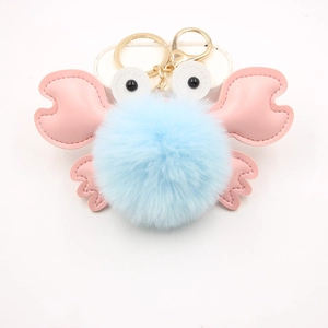 Detail of light blue faux fur crab keychain with pink leather claws and golden metal hook