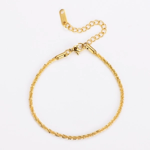 Close-up of golden twisted rope chain bracelet in stainless steel with shiny finish