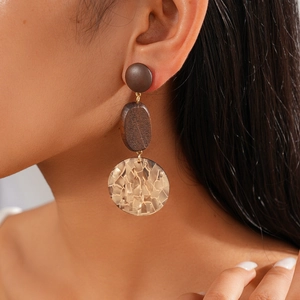 Three-tier long earrings with wooden accents and resin pendants on model's ear