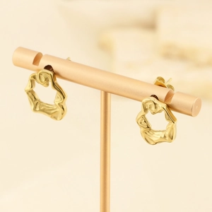 Boucles d'oreilles dorées texturées irrégulières présentées sur un support en métal rose