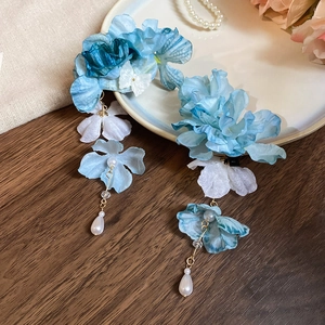 Détail d'une pince à cheveux fleurs de soie bleu et blanc avec long gland et perles