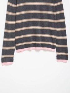 Detail of grey striped knit sweater with pink ribbed cuffs and layered hem design