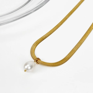 Gold snake chain necklace with freshwater pearl pendant displayed on a minimalist background