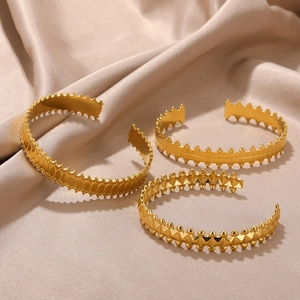 Three-piece set of polished golden stainless steel bangles with geometric patterns on silk