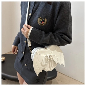 Detail of white heart-shaped bag with bat wings and lace-up design in smooth PU leather