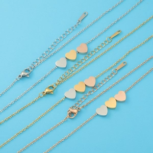 Detailed shot of three titanium steel heart pendants in silver, gold, and rose gold finish
