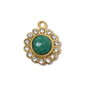 Detailed macro view of a gold flower pendant with green gemstone and white crystals