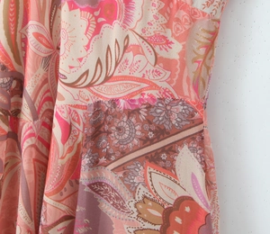 Close-up of side seam stitching on women's paisley print dress with high-density colors