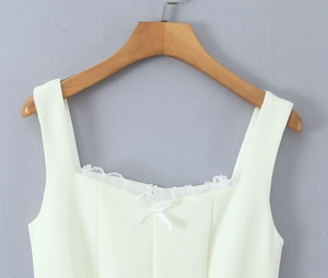 Nahaufnahme der weißen Spitzenkante am Ausschnitt mit kleiner Schleife am Sommerkleid