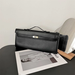 Detail of minimalist black PU leather handbag with elegant gold metal buckle closure