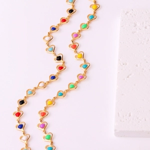 Colorful enamel heart link gold necklace for women on a white textured stone