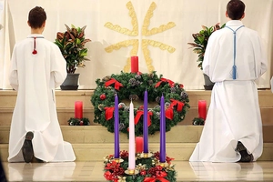 Religious advent wreath with festive candles and ceremonial robes on altar