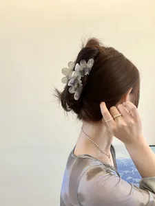 Rear view of elegant acetate flower hair claw in purple marble pattern on model hair