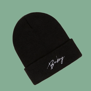 Detail of the white Baby embroidery on the fold of this black knit beanie cap