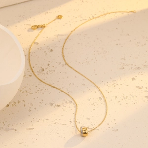 Élégant collier en acier inoxydable doré avec un pendentif cylindrique serti de cristaux