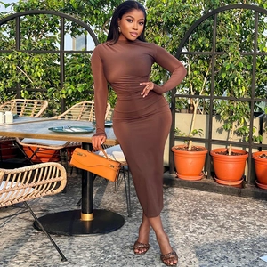 Brown long sleeve bodycon maxi dress in ribbed knit fabric worn by model in garden