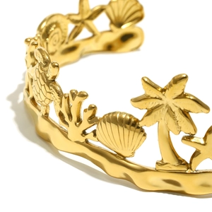 Detail of 18K gold-plated bangle featuring sea turtle, starfish and coral relief icons
