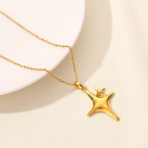 Detailed macro view of 18k gold plated stainless steel four-pointed star pendant on necklace