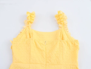 Detail view of yellow textured summer dress featuring ruffled straps and invisible back zipper