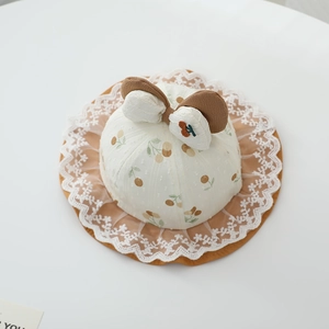 Detailed view of baby sun hat with cherry print, lace brim, and cute bow decoration