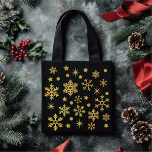 Detail of black canvas tote bag with gold glitter snowflake prints for Christmas gifts