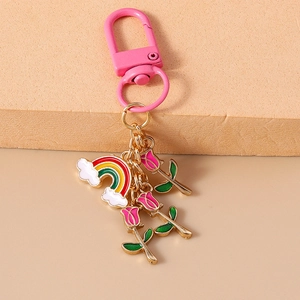 Detailed view of rainbow cloud and pink tulip enamel charms on a stylish keychain