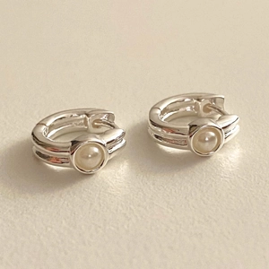 925 Sterling Silver hoop earrings featuring elegant white pearls on a creamy surface