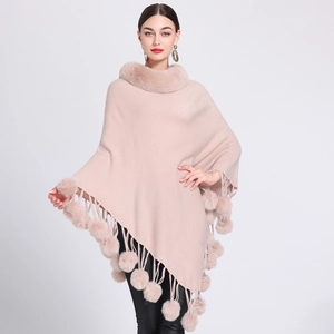 Detailed knit of pink poncho showing faux rabbit fur collar and fluffy pom-pom fringe