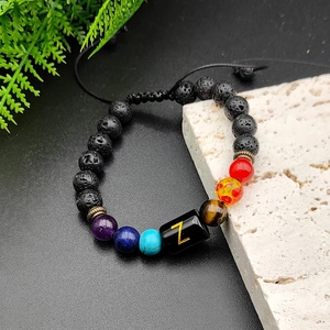 Bracelet en pierre de lave chakra avec breloque lettre Z dorée sur fond de pierre naturelle