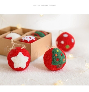 Close-up of handmade Christmas wool felt ornaments in gift box with festive warm lighting