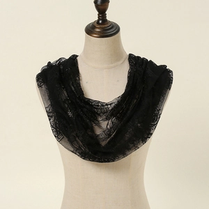Detail of black lace scarf with delicate patterns on a beige mannequin bust