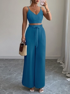 Dettaglio di un completo blu due pezzi con top a trapezio e pantaloni larghi con cintura