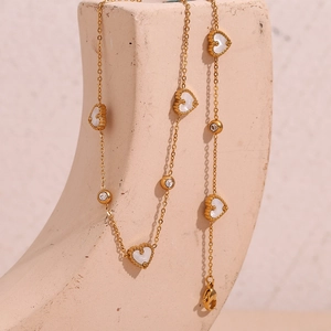 Close-up of 18K gold plated necklace featuring white shell hearts and round zircon stones