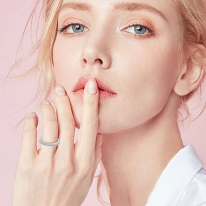 Sparkling Moissanite eternity ring in S925 sterling silver worn by a model on a pink background