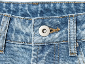 Dettaglio della vita dei jeans blu con bottone in metallo argento e cuciture gialle