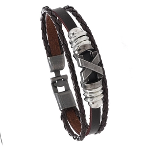 Detail of brown braided leather bracelet with silver X-shaped metal charm and clasp