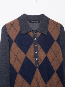 Detail of argyle knit polo shirt showing brown and navy diamond patterns with buttons