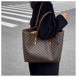Foto street style di una borsa shopper marrone con stampa monogramma M e manici sottili
