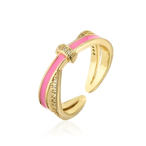 Macro detail of cross design ring with 18K gold plating, pink enamel and zircons
