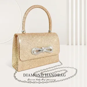 Elegant gold glitter evening clutch with sparkling rhinestone bow and circular handle
