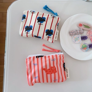 Detail view of cotton coin pouches featuring cute rabbit and cat prints with simple wish label