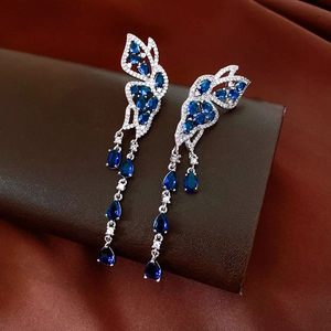 Détail de boucles d'oreilles papillon en argent avec zircon bleu et cristaux brillants