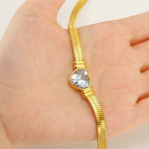 Close-up of heart-shaped zircon on 18K gold plated herringbone snake chain necklace