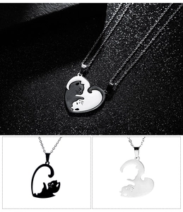 Macro detail of interlocking black and silver cat heart pendants with polished steel chain