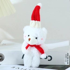 Close-up of cute plush bear with red knitted Christmas hat and scarf detail