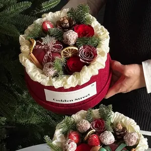 Christmas round flower box with red roses, pine cones and cinnamon sticks for holiday gifts