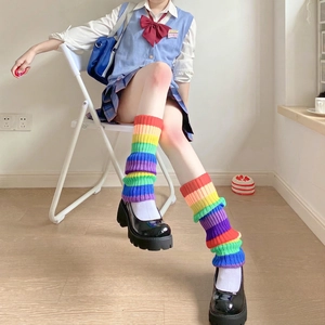 Macro detail of rainbow striped knit leg warmers showing colorful ribbing texture